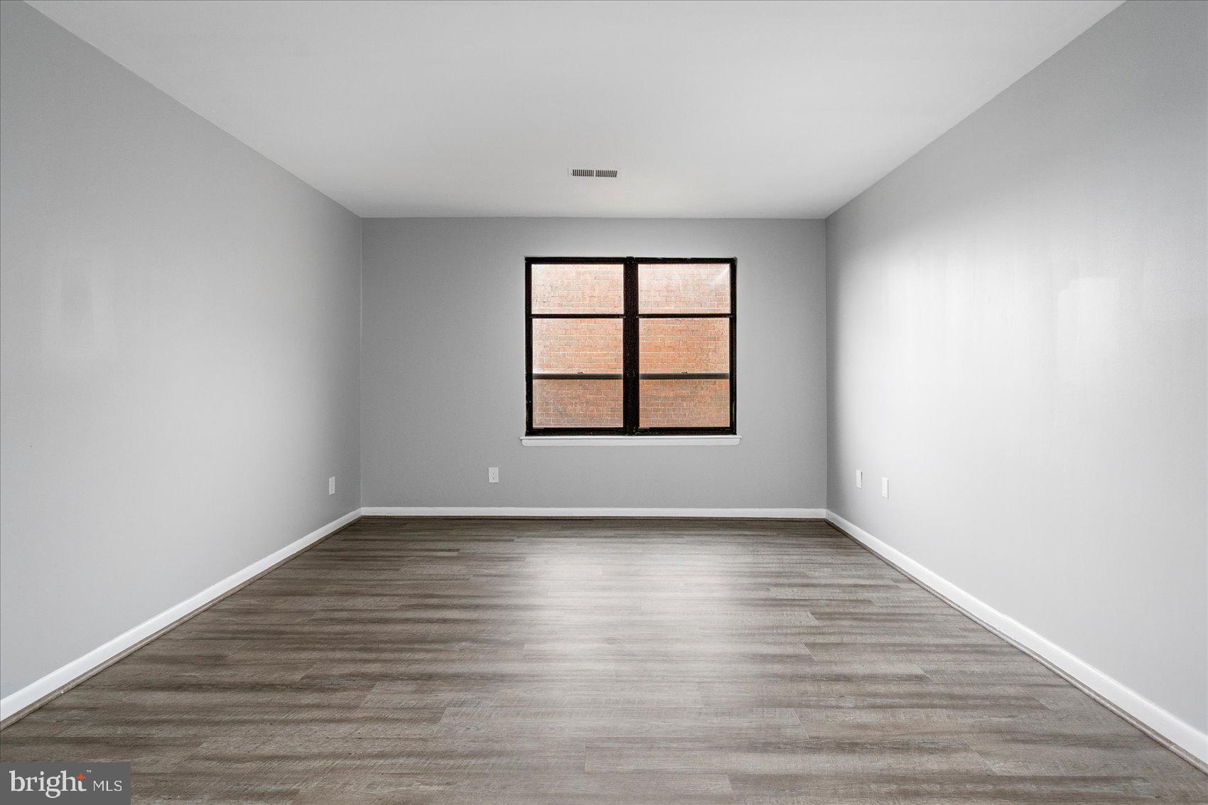 6317 Park Heights Avenue, Unit 616 Baltimore, MD 21215 - Photo 25 of 36 wooden floor in an empty room with a window