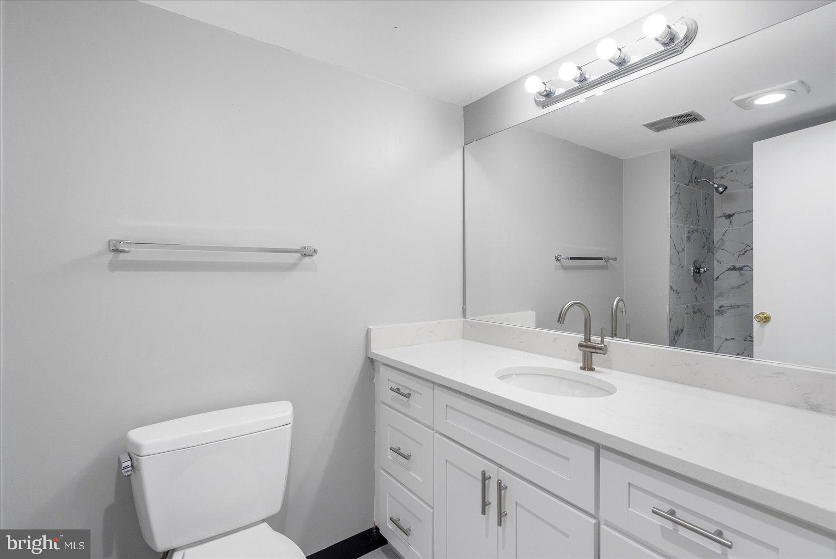 6317 Park Heights Avenue, Unit 616 Baltimore, MD 21215 - Photo 28 of 36 a bathroom with a toilet sink and mirror