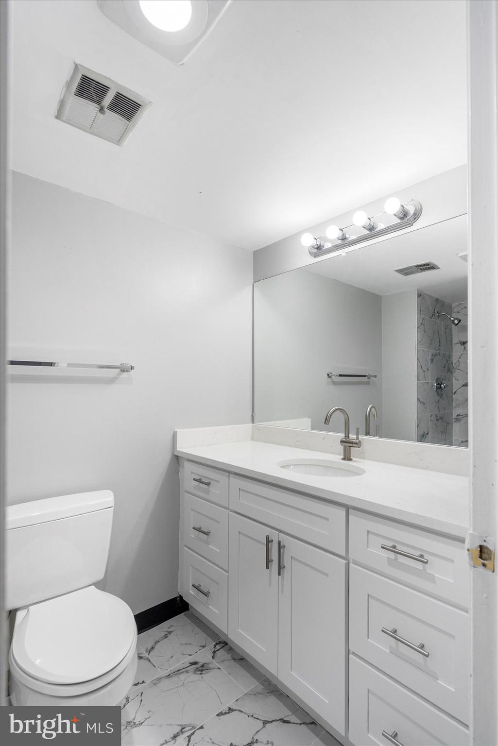 6317 Park Heights Avenue, Unit 616 Baltimore, MD 21215 - Photo 30 of 36 a bathroom with a toilet sink and mirror