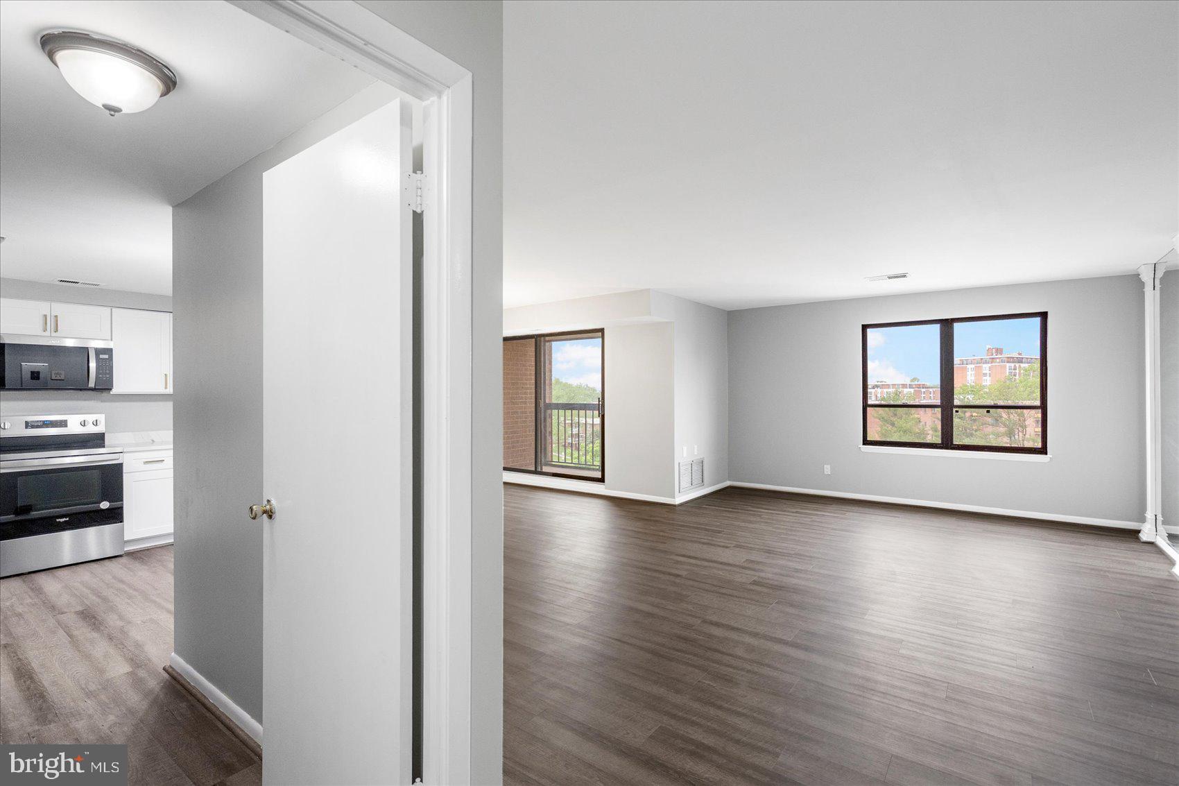 6317 Park Heights Avenue, Unit 616 Baltimore, MD 21215 - Photo 33 of 36 an empty room with wooden floor kitchen view and windows