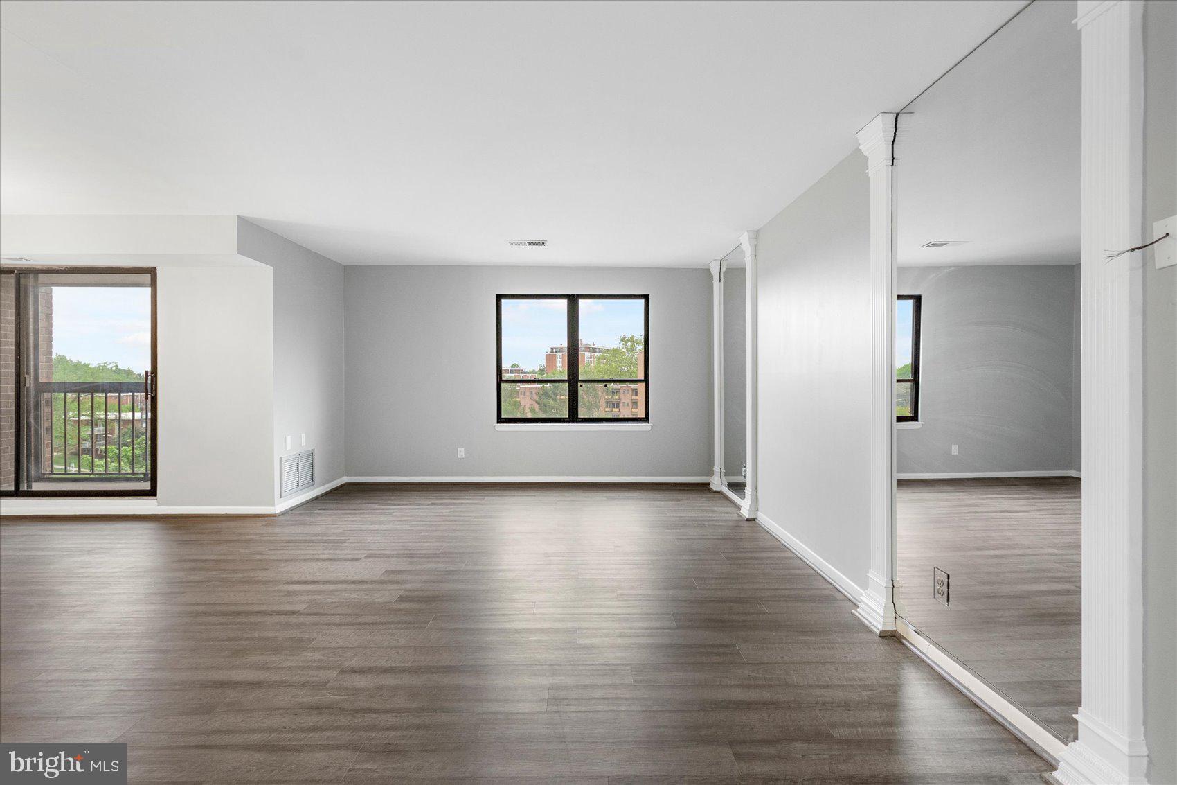 6317 Park Heights Avenue, Unit 616 Baltimore, MD 21215 - Photo 4 of 36 an empty room with wooden floor and windows