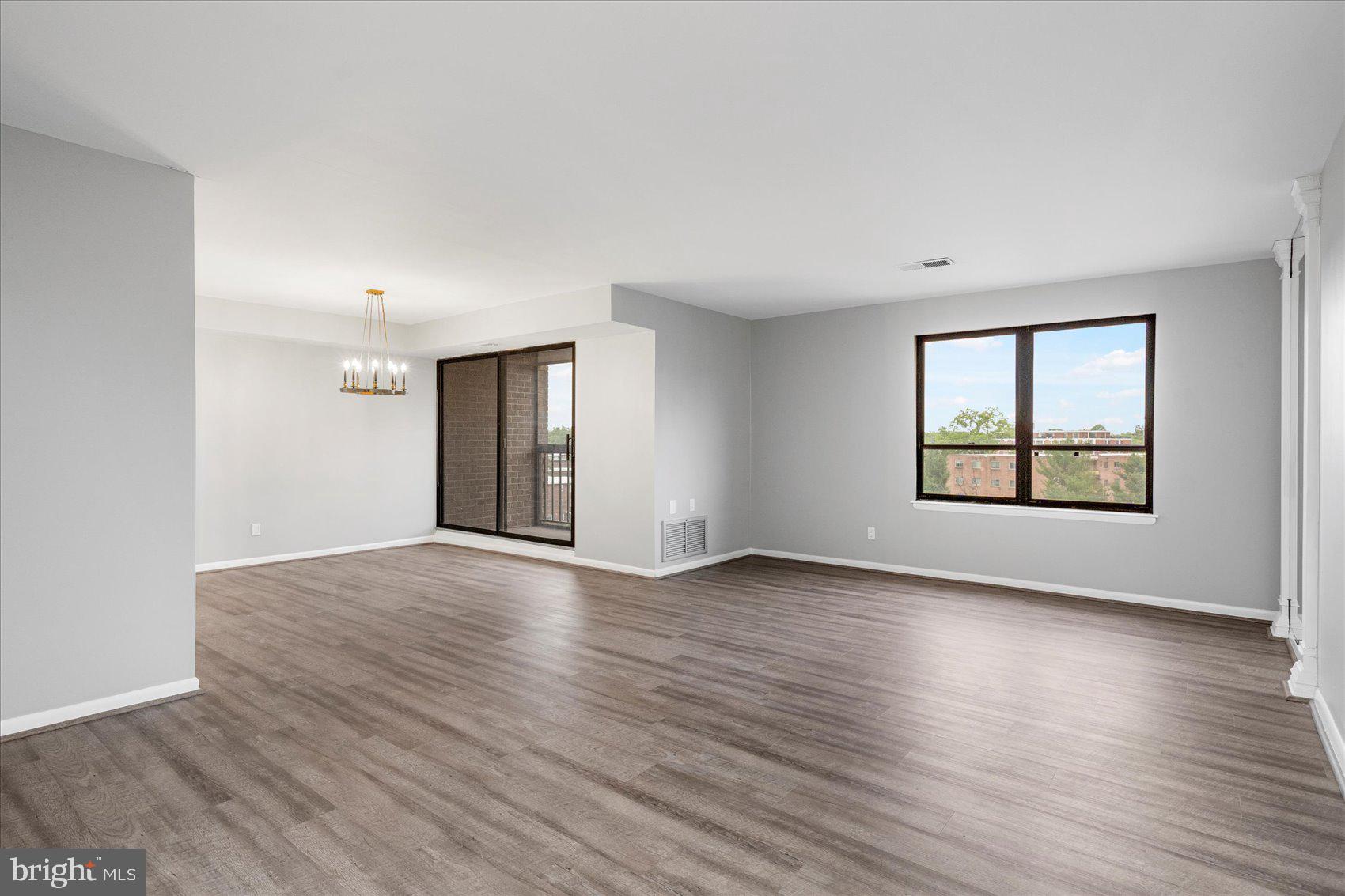 6317 Park Heights Avenue, Unit 616 Baltimore, MD 21215 - Photo 5 of 36 an empty room with wooden floor and windows