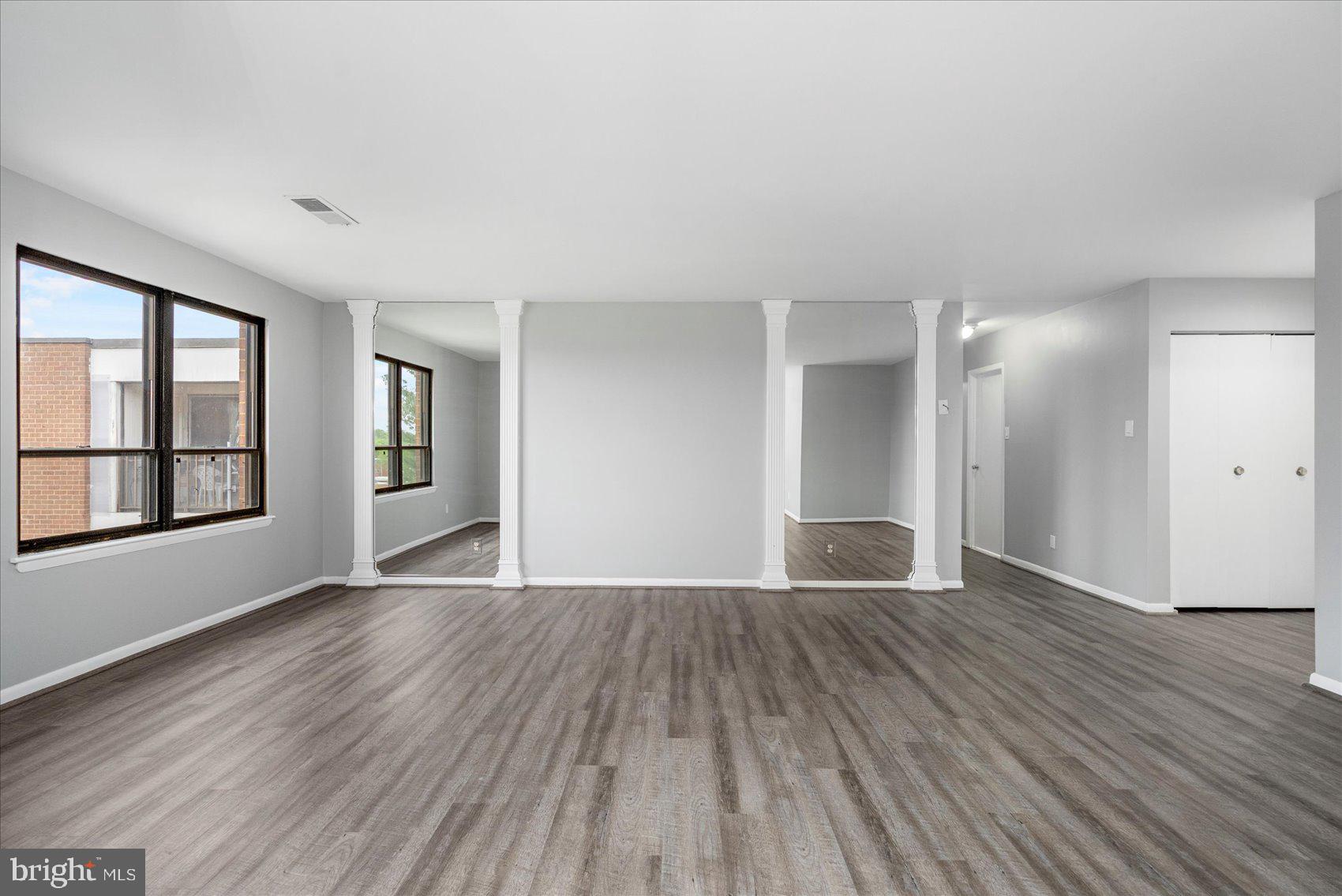 6317 Park Heights Avenue, Unit 616 Baltimore, MD 21215 - Photo 8 of 36 wooden floor in an empty room with a window