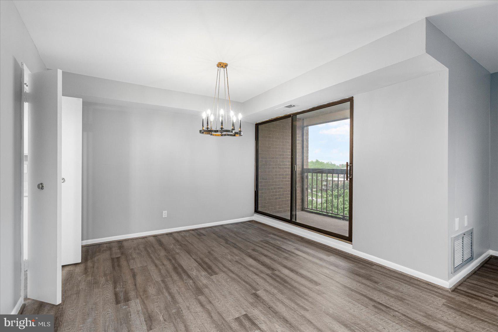 6317 Park Heights Avenue, Unit 616 Baltimore, MD 21215 - Photo 10 of 36 a view of an empty room with wooden floor and a window