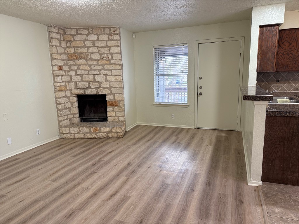 9810 Roxanna Drive, Unit C Austin, TX 78748 - Photo 2 of 10 a view of empty room with wooden floor and fireplace