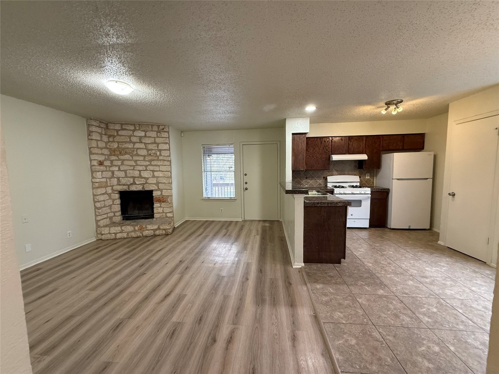 9810 Roxanna Drive, Unit C Austin, TX 78748 - Photo 10 of 10 an empty room with wooden floor kitchen view and a window