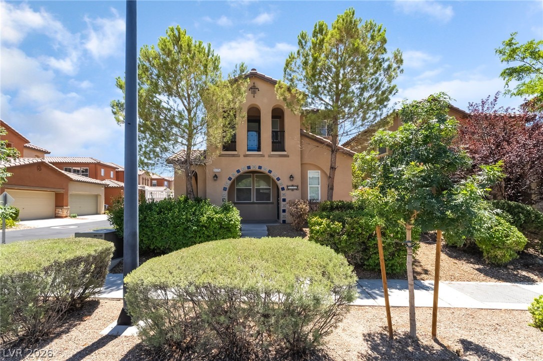 3175 Via Seranova Henderson, NV 89044 - Photo 2 of 45 This charming home showcases a unique architectural style with a welcoming facade and lush landscaping.
