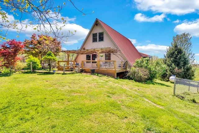 a view of a house with a yard and sitting area