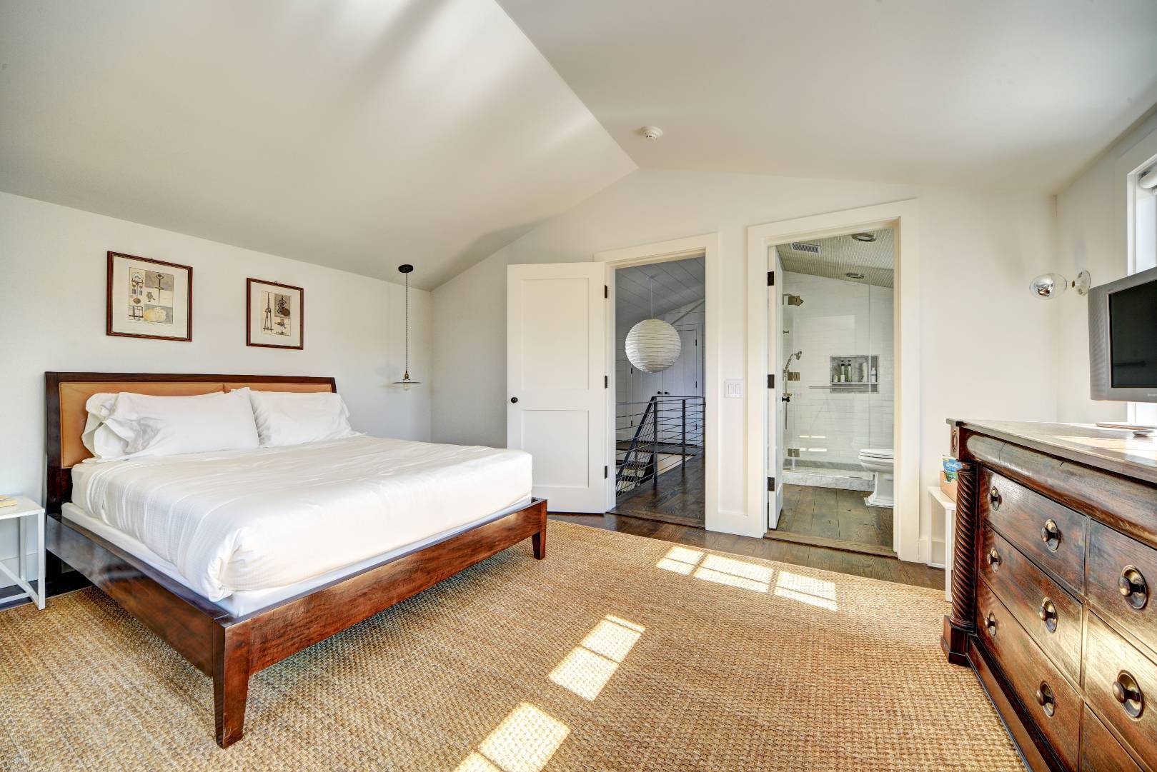 295 Main Street Sag Harbor, NY 11963 - Photo 11 of 21 a bedroom with a large bed and a chandelier