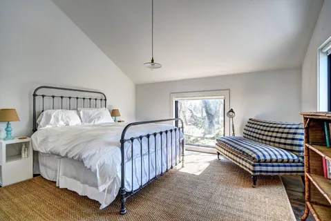 a bed sitting in a bedroom next to a window