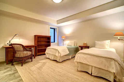 a bedroom with two beds and a chair