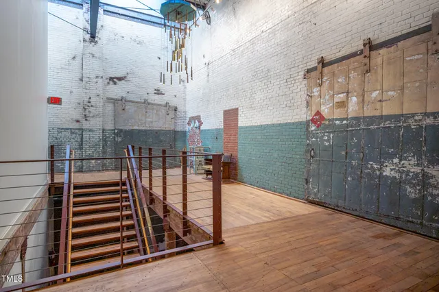 a sign of golf club on a wall under a large tree