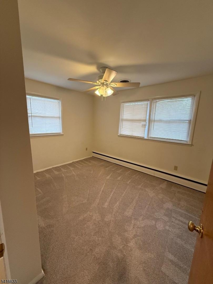 4032 Quakerbridge Road Lawrence Township, NJ 08648 - Photo 6 of 9 an empty room with a chandelier fan and windows