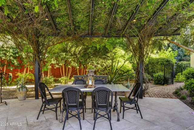 a backyard of a house with table and chairs large trees