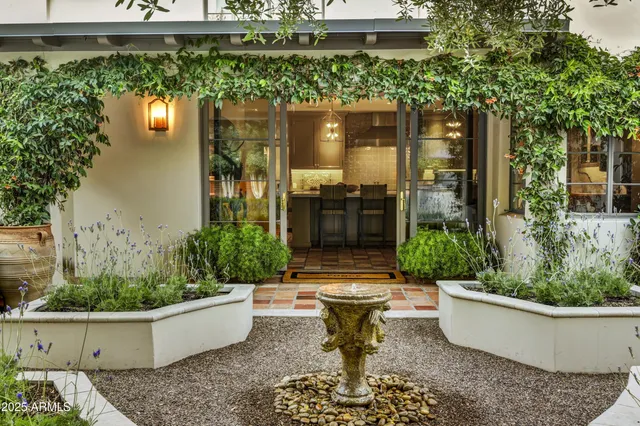 a view of a house with potted plants and a fountain