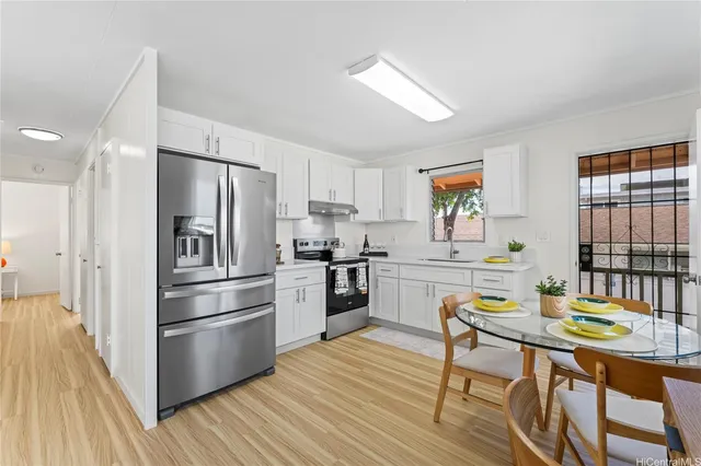 a kitchen with stainless steel appliances a refrigerator a stove a dining table and chairs