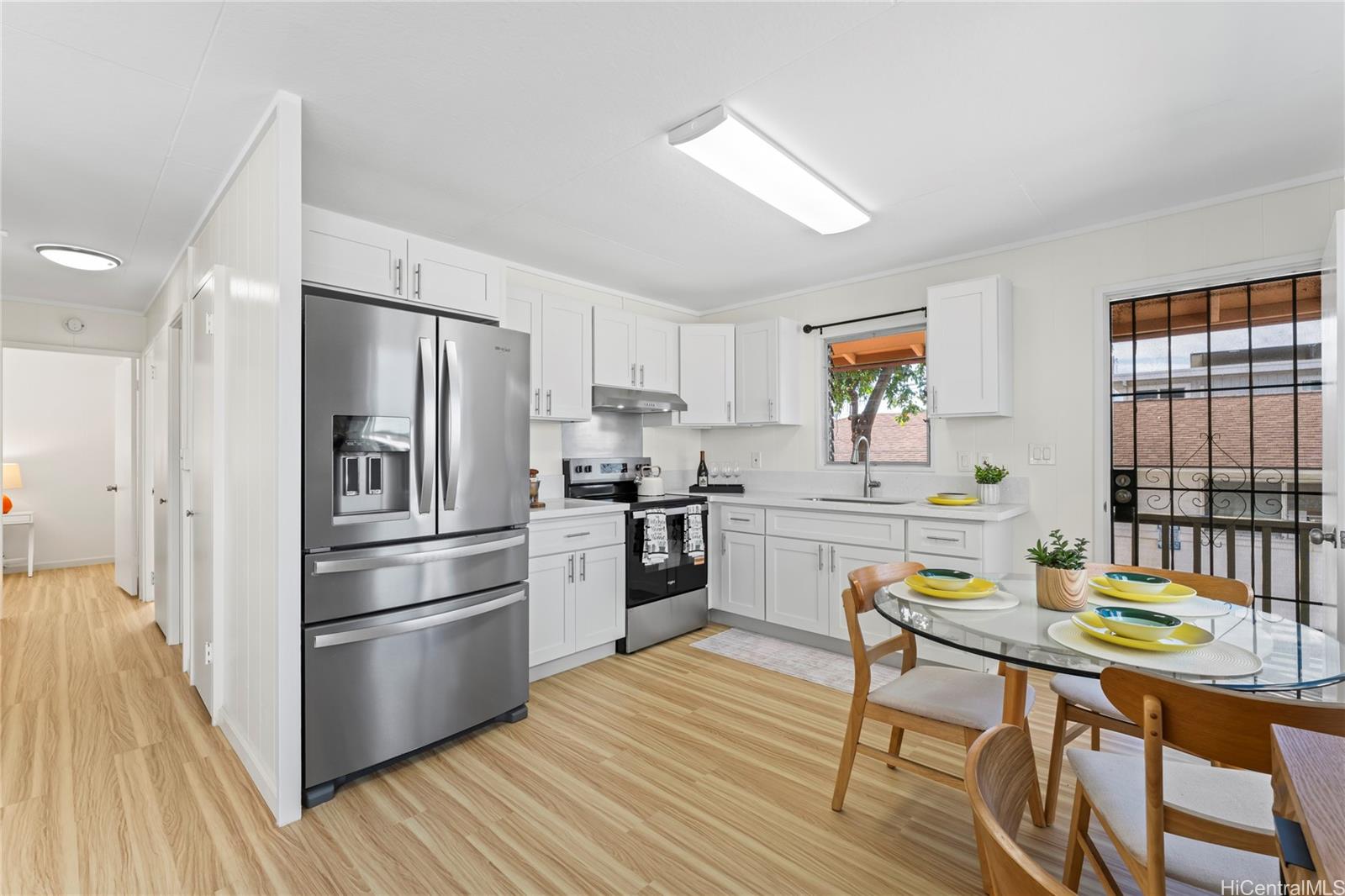 125 Milo Lane Honolulu, HI 96813 - Photo 3 of 16 a kitchen with stainless steel appliances a refrigerator a stove a dining table and chairs