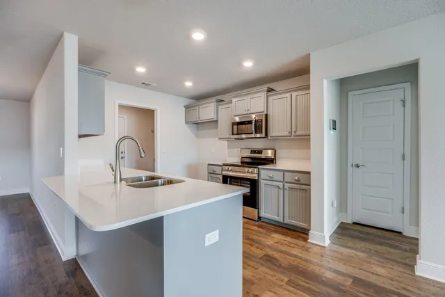 a kitchen with kitchen island stainless steel appliances a sink and refrigerator