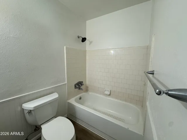 a white toilet sitting next to a bath tub