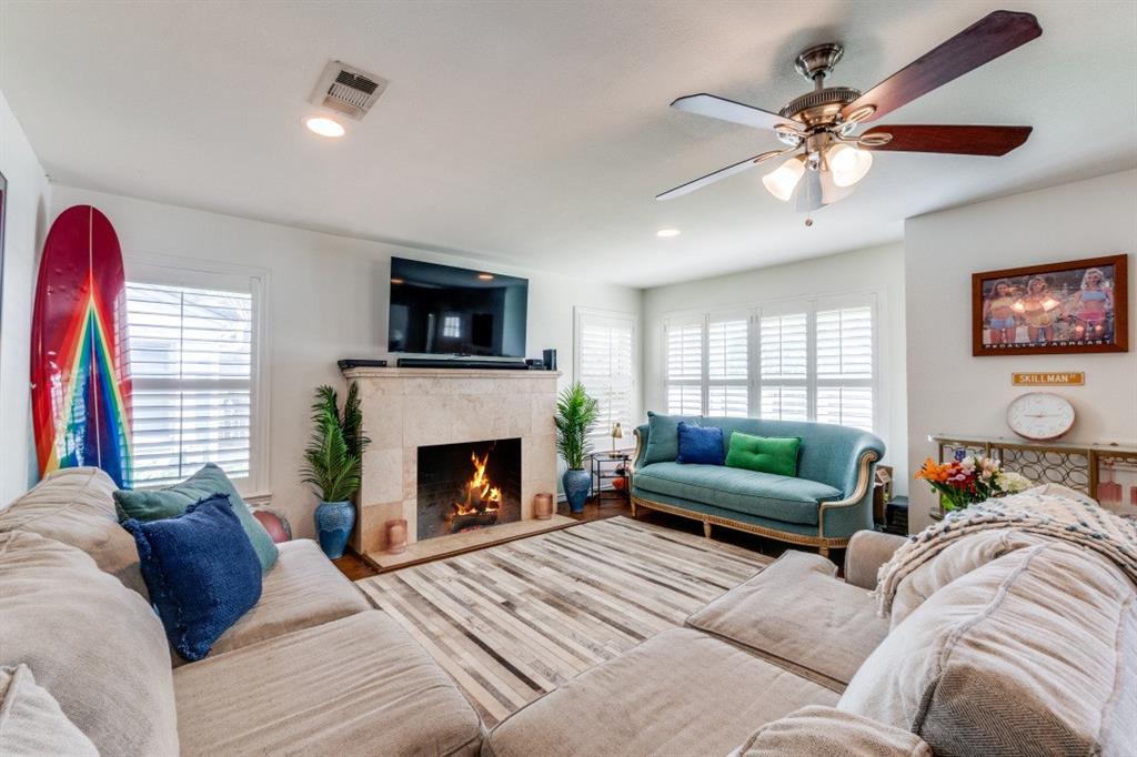 4303 Skillman Street Dallas, TX 75206 - Photo 6 of 25 a living room with furniture a flat screen tv and a fireplace