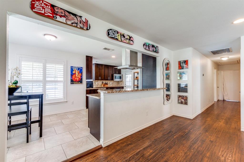 4303 Skillman Street Dallas, TX 75206 - Photo 9 of 25 a kitchen with stainless steel appliances kitchen island granite countertop a refrigerator and a stove top oven