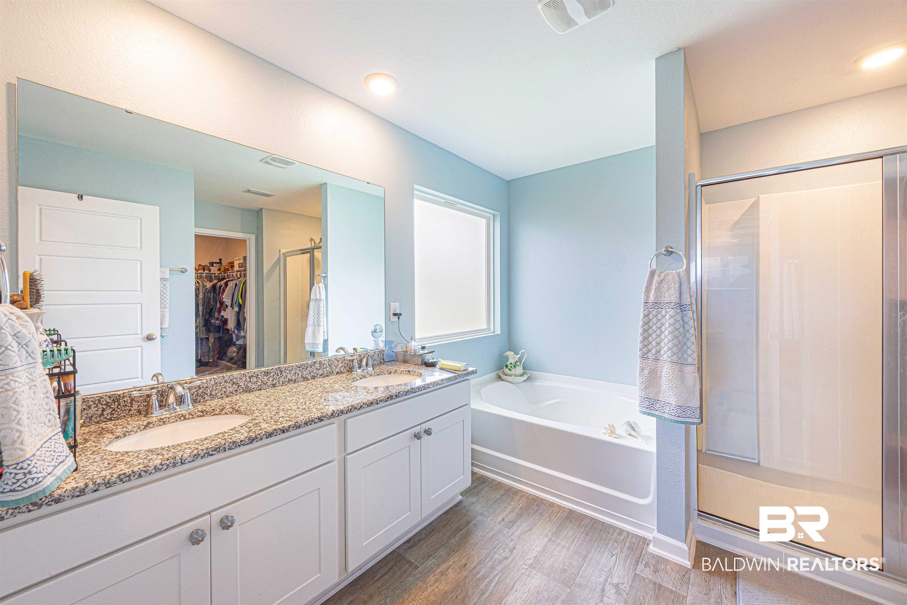 14843 Forsythia Loop Silverhill, AL 36576 - Photo 25 of 51 Bathroom featuring double vanity, a stall shower, a spacious closet, a bath, and dark wood-style floors