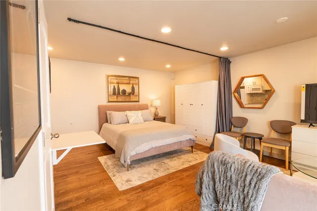 a spacious bedroom with a bed a mirror and a large window with outer view