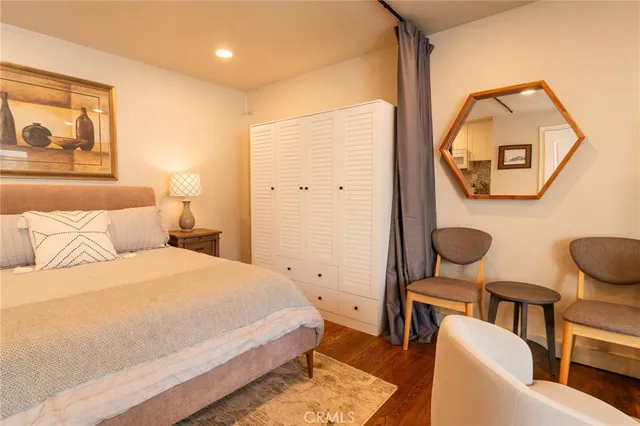 a bedroom with a bed mirror and painting on the wall