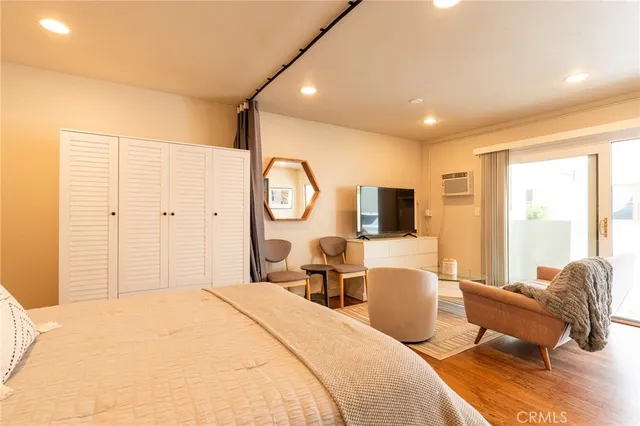 a bedroom with a large bed and a flat screen tv