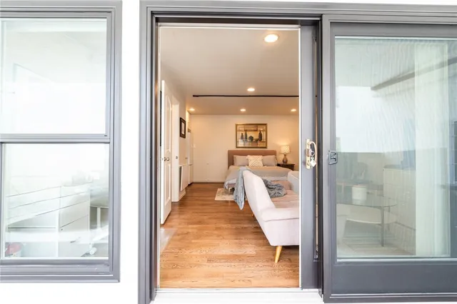 a view of a hallway with wooden floor and a living room