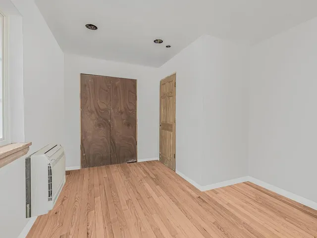 a view of a room with wooden floor and white walls