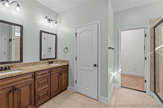 a spacious bathroom with a granite countertop sink a mirror and a shower