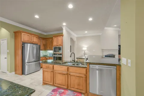 a kitchen with stainless steel appliances granite countertop a refrigerator and a sink