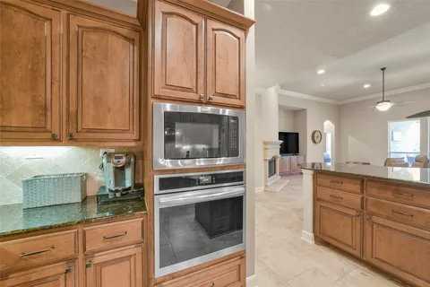 a kitchen with granite countertop wooden cabinets and stainless steel appliances