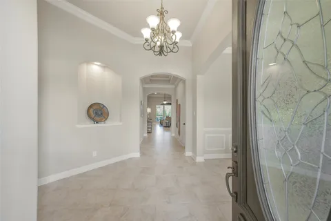 a view of a hallway view with chandelier fan and wooden floor