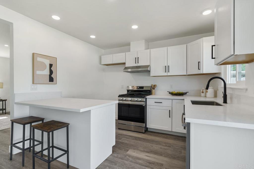 935 Swallow Drive Vista, CA 92083 - Photo 17 of 43 a kitchen with stainless steel appliances granite countertop a stove a sink dishwasher and a refrigerator with white cabinets