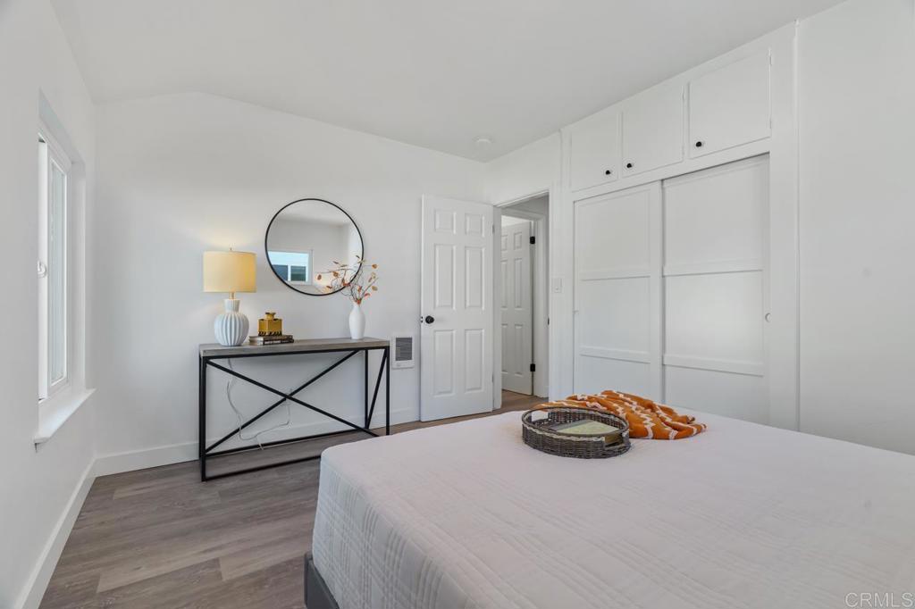 935 Swallow Drive Vista, CA 92083 - Photo 27 of 43 a bedroom with a bed a table and a large mirror