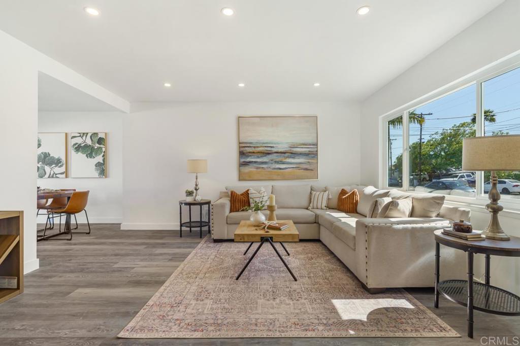 935 Swallow Drive Vista, CA 92083 - Photo 9 of 43 a living room with couches and a dining table with wooden floor