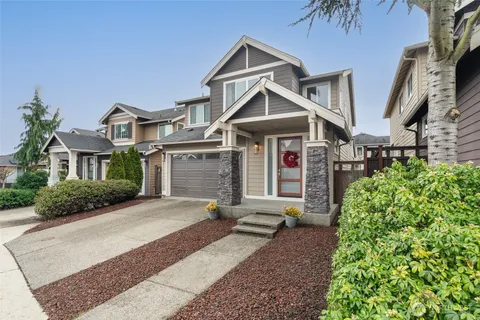 a front view of a house with a yard and potted plants