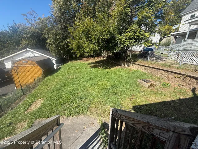 a view of a yard with wooden fence