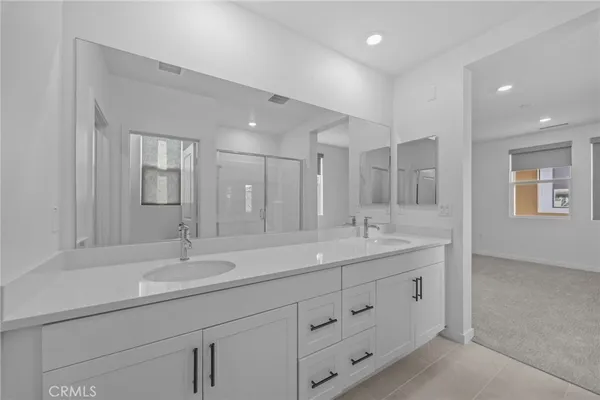 a bathroom with double vanity sinks and a mirror
