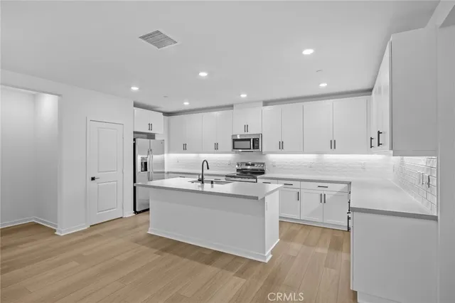 a view of a kitchen with stainless steel appliances granite countertop a stove a sink and a refrigerator