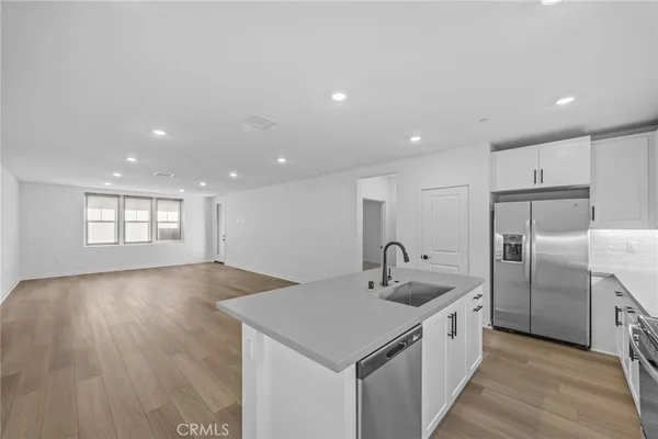 a kitchen with stainless steel appliances granite countertop a sink and a refrigerator