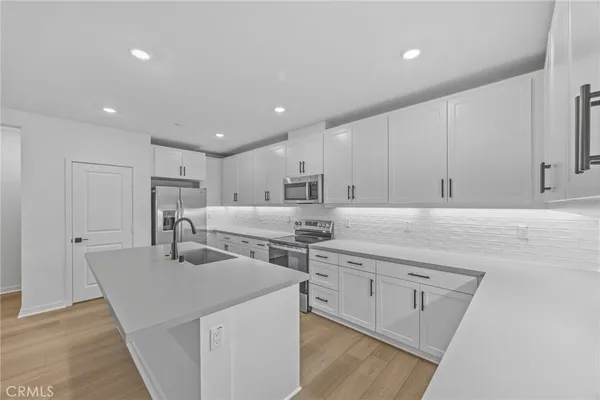 a kitchen with stainless steel appliances kitchen island granite countertop a sink and cabinets