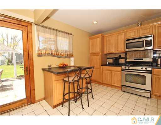 19 New Road Kendall Park, NJ 08824 - Photo 10 of 21 a kitchen with stainless steel appliances kitchen island granite countertop a stove a sink and a microwave