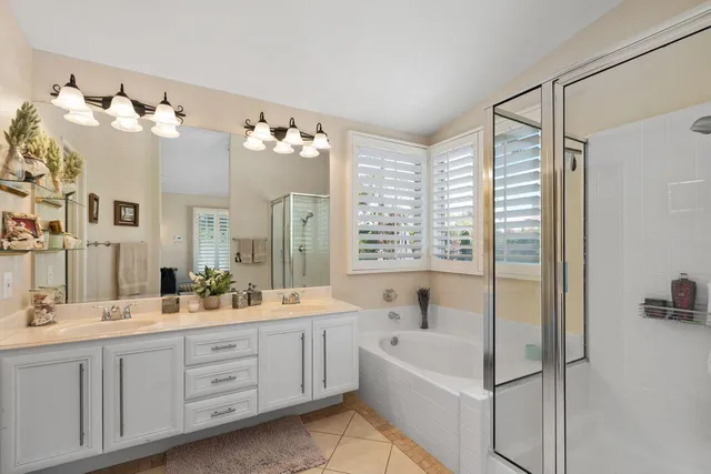 a bathroom with a double vanity sink mirror and bathtub