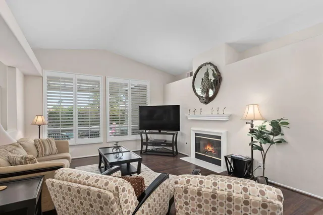 a living room with furniture a fireplace and a flat screen tv
