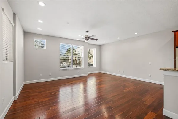 a view of a room with wooden floor and a ceiling fan
