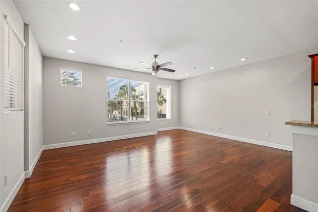 a view of a room with wooden floor and a ceiling fan