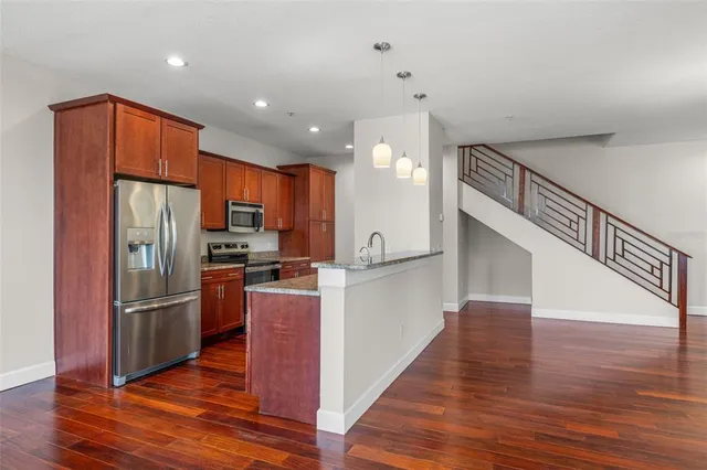 a kitchen with stainless steel appliances granite countertop a refrigerator and a stove top oven